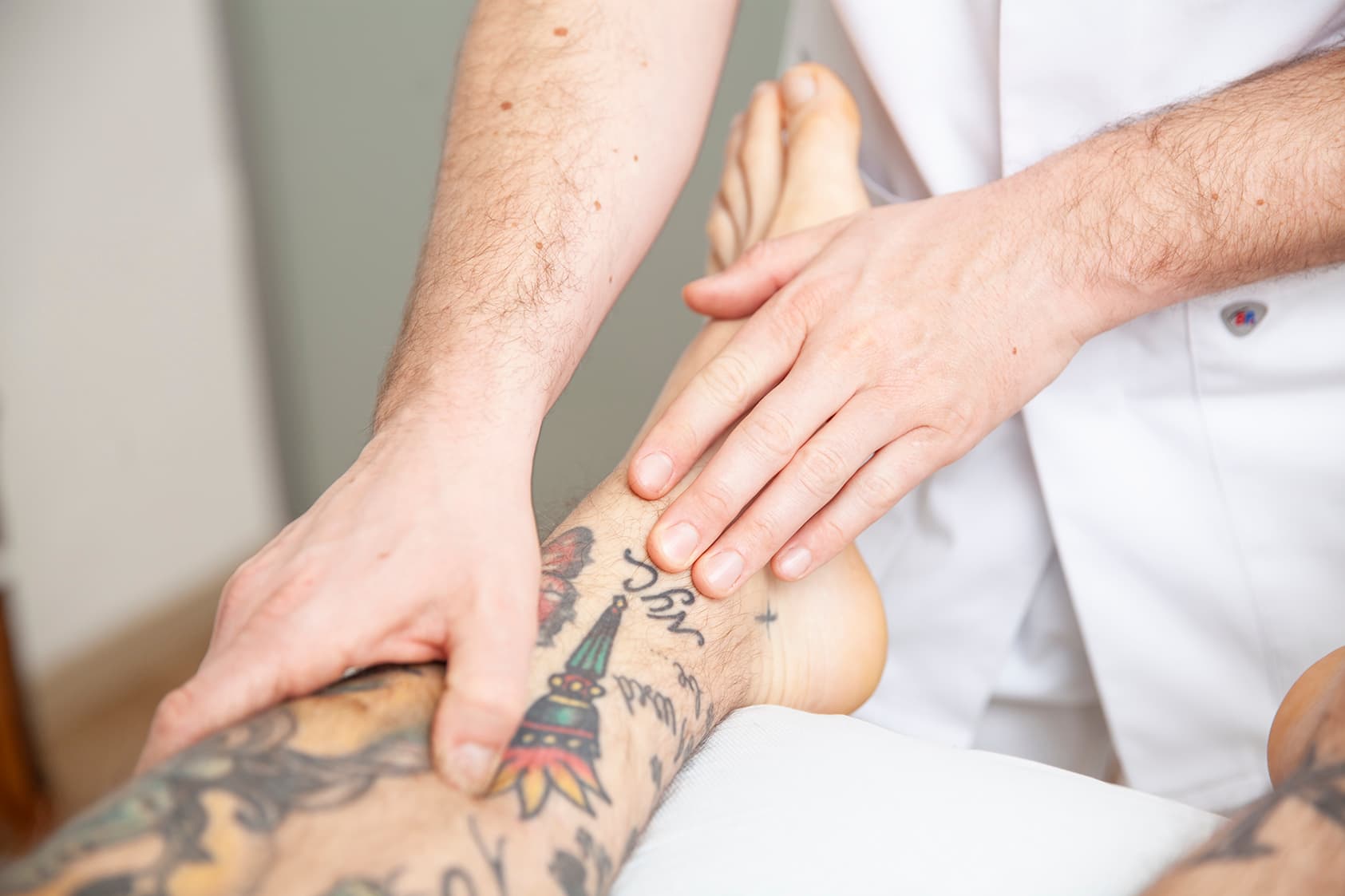 Heilpraktiker Rick Putzer wendet Leitbahnpalpation am Bein eines Patienten an