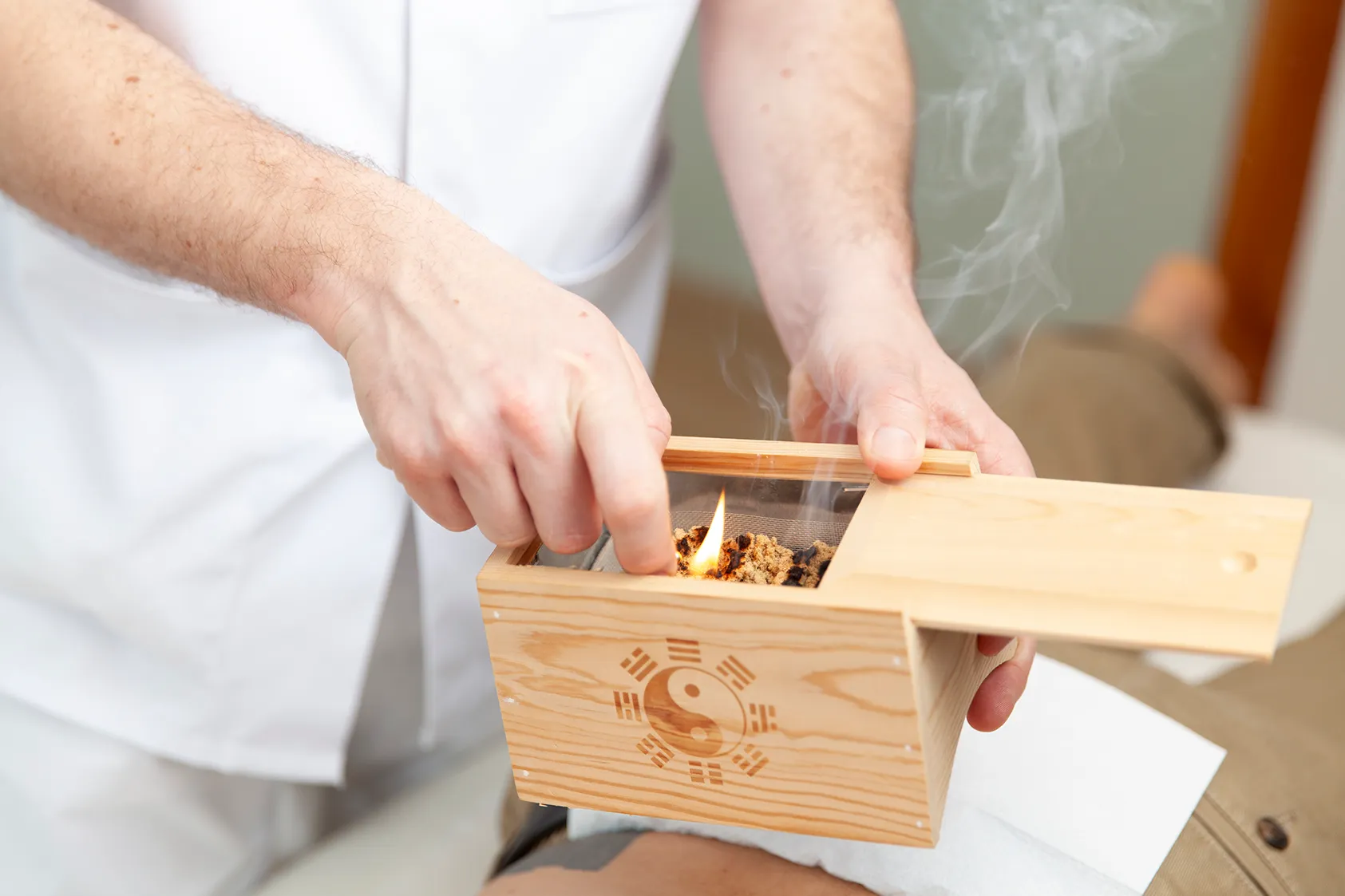 Heilpraktiker entzündet eine Moxabox