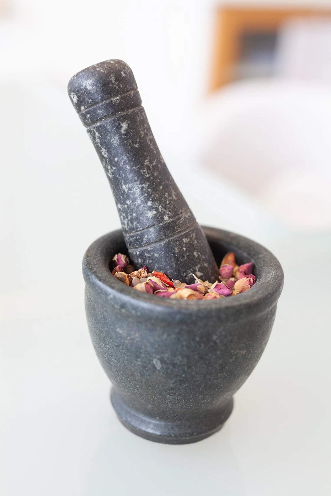 Arzneikräuter der TCM in einem Mörser aus Stein.